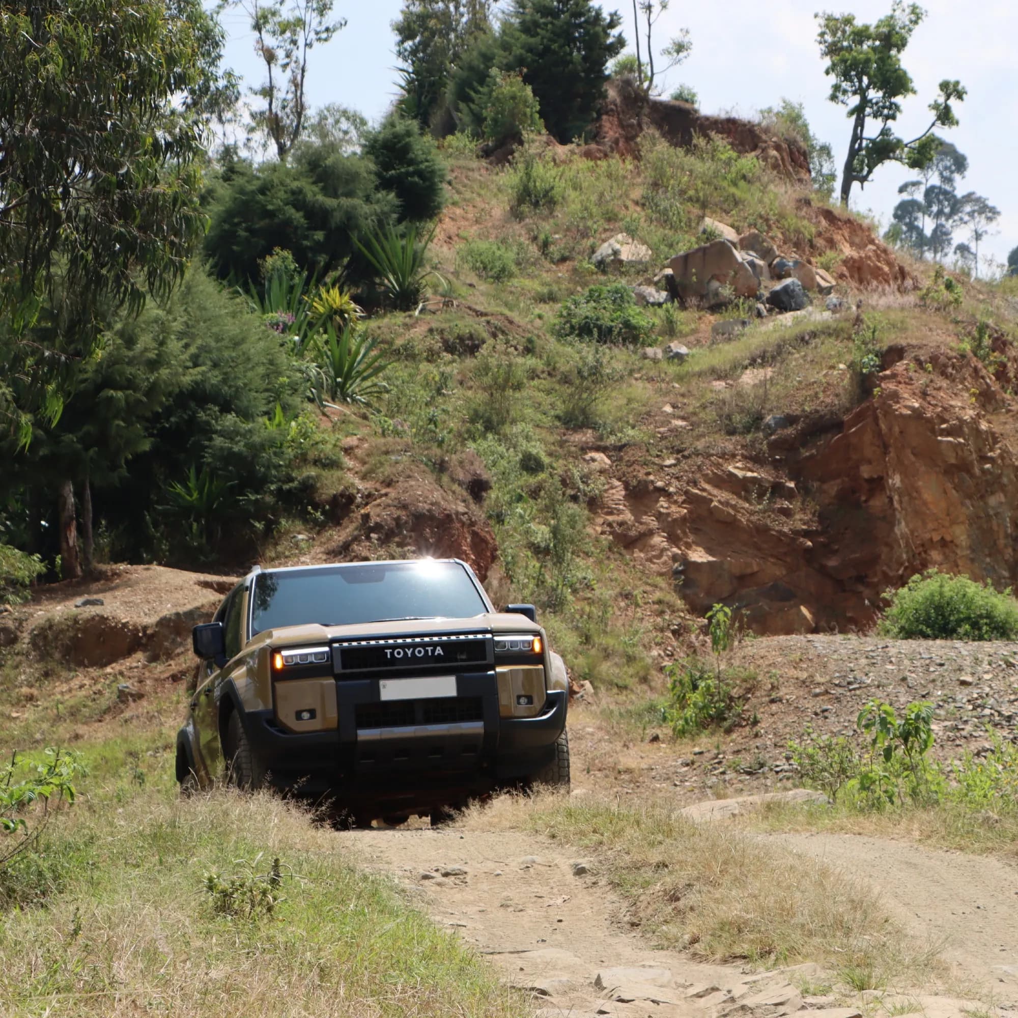 A Land Cruiser climbing a red earth track